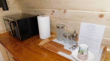 Un intérieur en bois avec un four à micro-ondes, un porte-rouleau d’essuie-tout et un panneau affichant le menu.