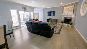 Relax in this stylish living room with a comfortable sofa, flat-screen TV, and cozy fireplace.