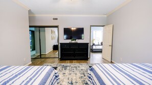 Relax in this serene bedroom with a large bed, dresser, and flat-screen TV.