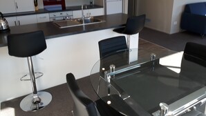 Une cuisine moderne dotée d’un îlot central, de tabourets de bar et d’une table à manger.
