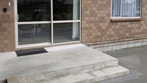 Un immeuble résidentiel doté d’une porte-fenêtre coulissante, d’une façade en briques et d’une allée en béton.