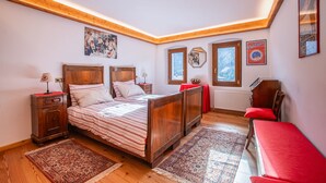 A bedroom with a wooden bed, a nightstand, a chair, and a window with a view of the sky. - Typical Cadore house, 15 minutes from Cortina, 4 big bedrooms and 3 bathrooms  (Vodo Di Cadore)