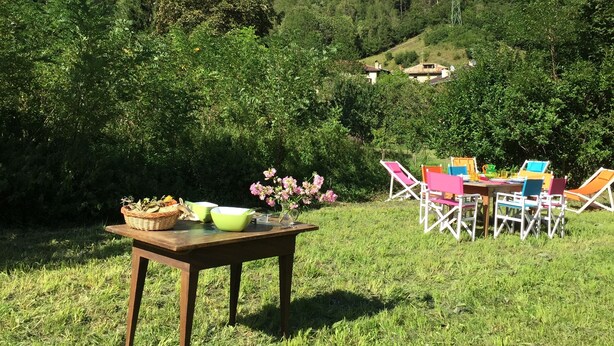 A picnic setup with a table and chairs in a grassy area, with a mountain range in the background. - Typical Cadore house, 15 minutes from Cortina, 4 big bedrooms and 3 bathrooms  (Vodo Di Cadore)