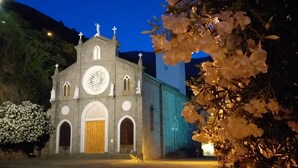 Une église dotée d’une grande fenêtre circulaire et de statues sur sa façade.