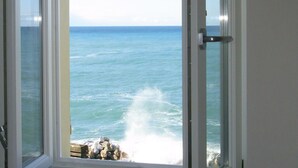 Une porte qui donne sur une pièce offrant une vue sur l’océan.