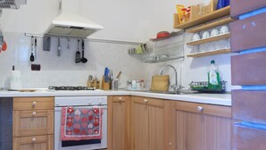 Una cocina con armarios de madera, estufa y lavaplatos.