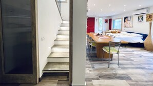 Un interior moderno con una escalera, un comedor y una sala de estar.