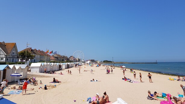 A beach with people sunbathing and playing, a Ferris wheel, and a pier in the background. - La Marina, Normandy, Apartment 4 people with sea view and port (Courseulles-sur-Mer)