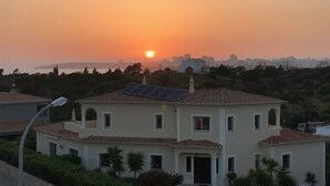 Ein zweistöckiges Haus mit Ziegeldach, Solaranlage und einer Straßenlaterne im Vordergrund.