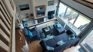Un salon moderne avec un ensemble de canapés, un téléviseur et une cheminée.