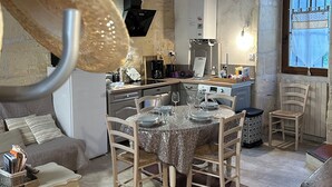 A cozy kitchen with a dining table set for four, a sofa, and a window with a view.