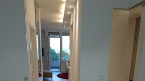 Een moderne hotelkamer met houten vloer, een bed, een bureau en uitzicht op het buitenland.