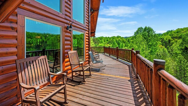 A wooden deck with chairs and a railing overlooking a forested area. - Ridge View Lodge • Nature/Mtn View • Hot tub • Firepit • Games • Parking 6 cars (Sevierville)