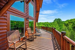 A wooden deck with chairs and a railing overlooking a forested area. - Ridge View Lodge • Nature/Mtn View • Hot tub • Firepit • Games • Parking 6 cars (Sevierville)