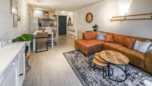 Ein modernes Wohnzimmer mit Sofa, Couchtisch und Essbereich.