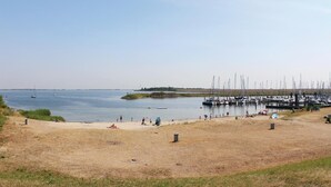 Ein Strand mit einer Marina im Hintergrund.