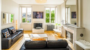 Una sala de estar moderna con chimenea, un sofá, una mesa de centro y un televisor.