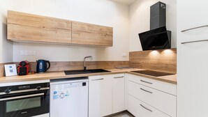 Una cocina moderna con armarios de madera, un microondas negro, un lavavajillas y un fregadero.