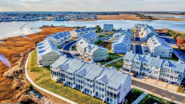 Zona residencial con casas modernas, una orilla de agua y un puente.