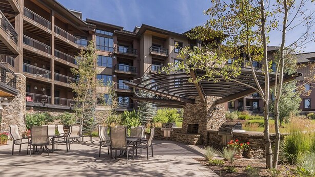 Un immeuble à plusieurs étages doté d’une terrasse extérieure et d’un patio couvert.