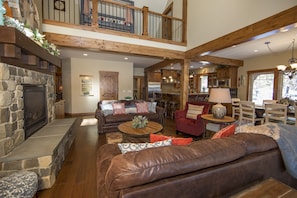 A spacious living area with a stone fireplace, leather sofas, and a dining area with wooden furniture. - Comfortable Clean Suncadia Family Home Sleeps12, FIREpit, HOTtub, BIKES, Pets ok (Cle Elum)
