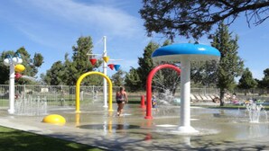 A water play area with various water features and a fenced perimeter. - Desert Sky, Eagle Crest Home. Golf on site, close to pool (Redmond)