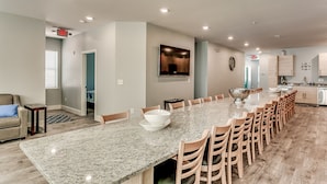 A spacious kitchen with a long granite countertop, wooden chairs, and a large island. - LARGE HOME w HUGE KITCHEN sleeps 50+huge pool+cinema+game room 1min to the SAND (North Myrtle Beach)