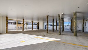 A spacious indoor area with concrete flooring, wooden pillars, and a view of a building outside. - LARGE HOME w HUGE KITCHEN sleeps 50+huge pool+cinema+game room 1min to the SAND (North Myrtle Beach)