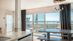 Una cocina con vista a la playa, un comedor y un amplio ventanal corredera.
