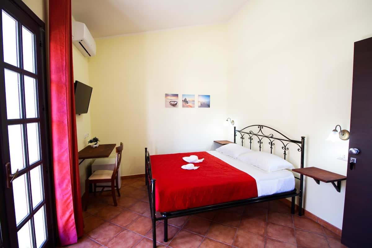 A bedroom with a bed, a desk, and a chair.