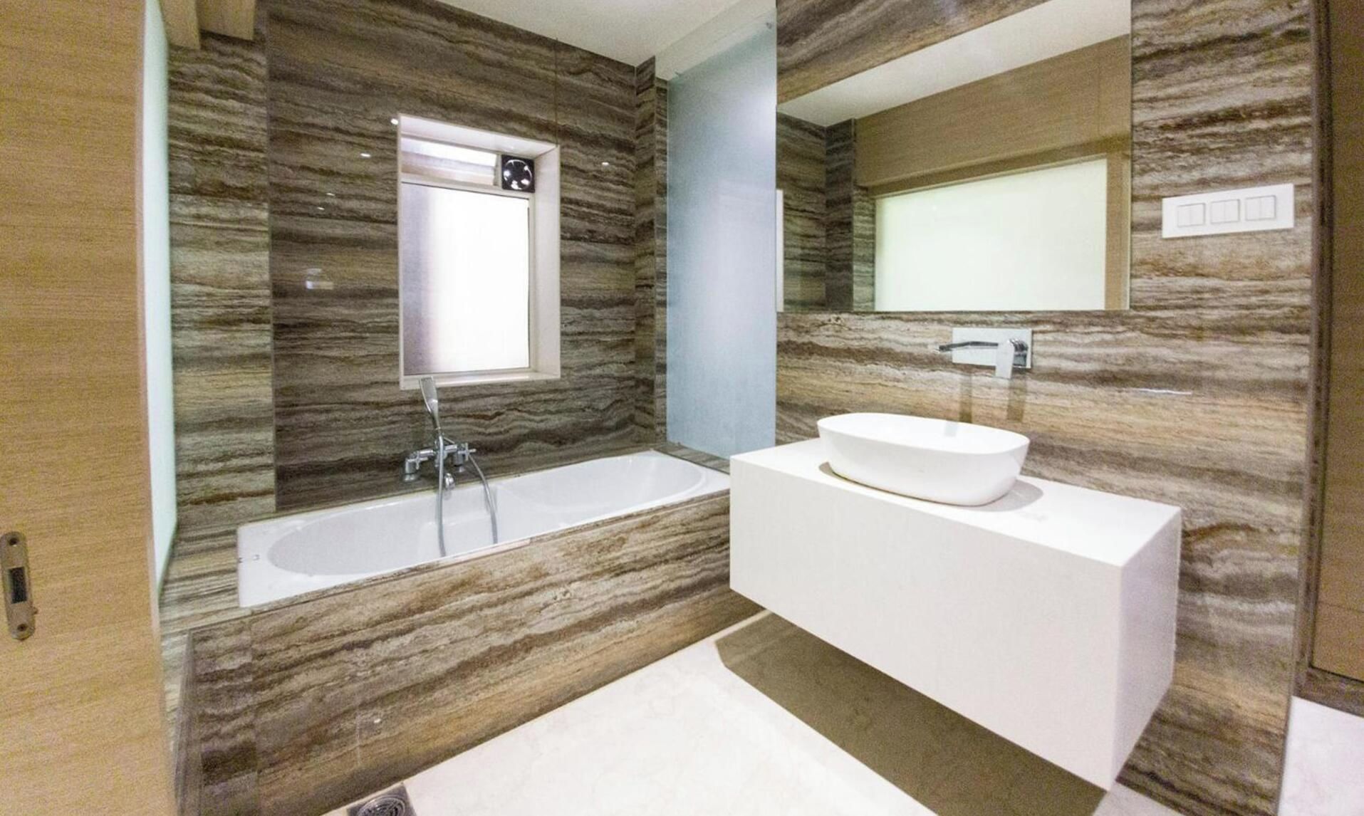 A modern bathroom with a freestanding bathtub, a vessel sink, and a large mirror.
