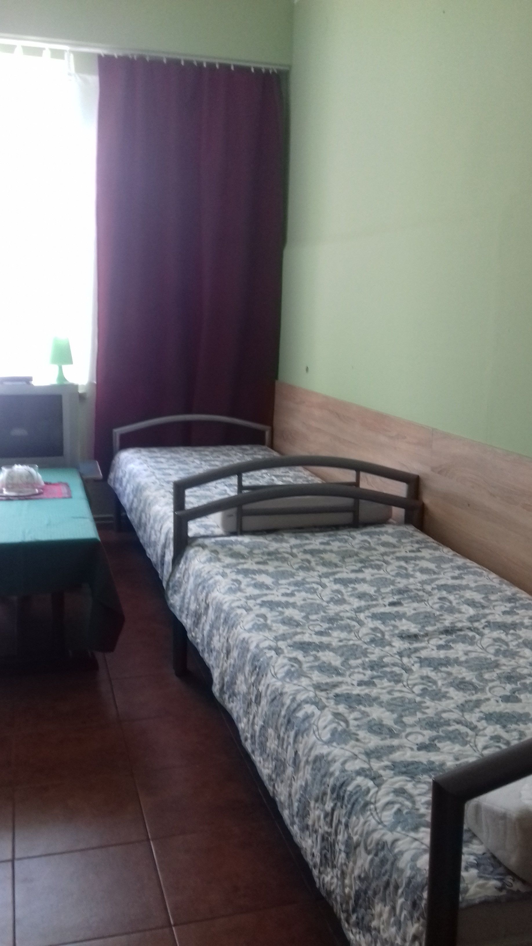 Une chambre de dortoir avec deux lits simples, une petite table et une chaise.