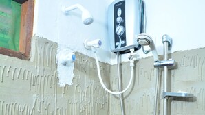 Une salle de bain équipée d’une douche, d’un robinet et d’un panneau de commande.