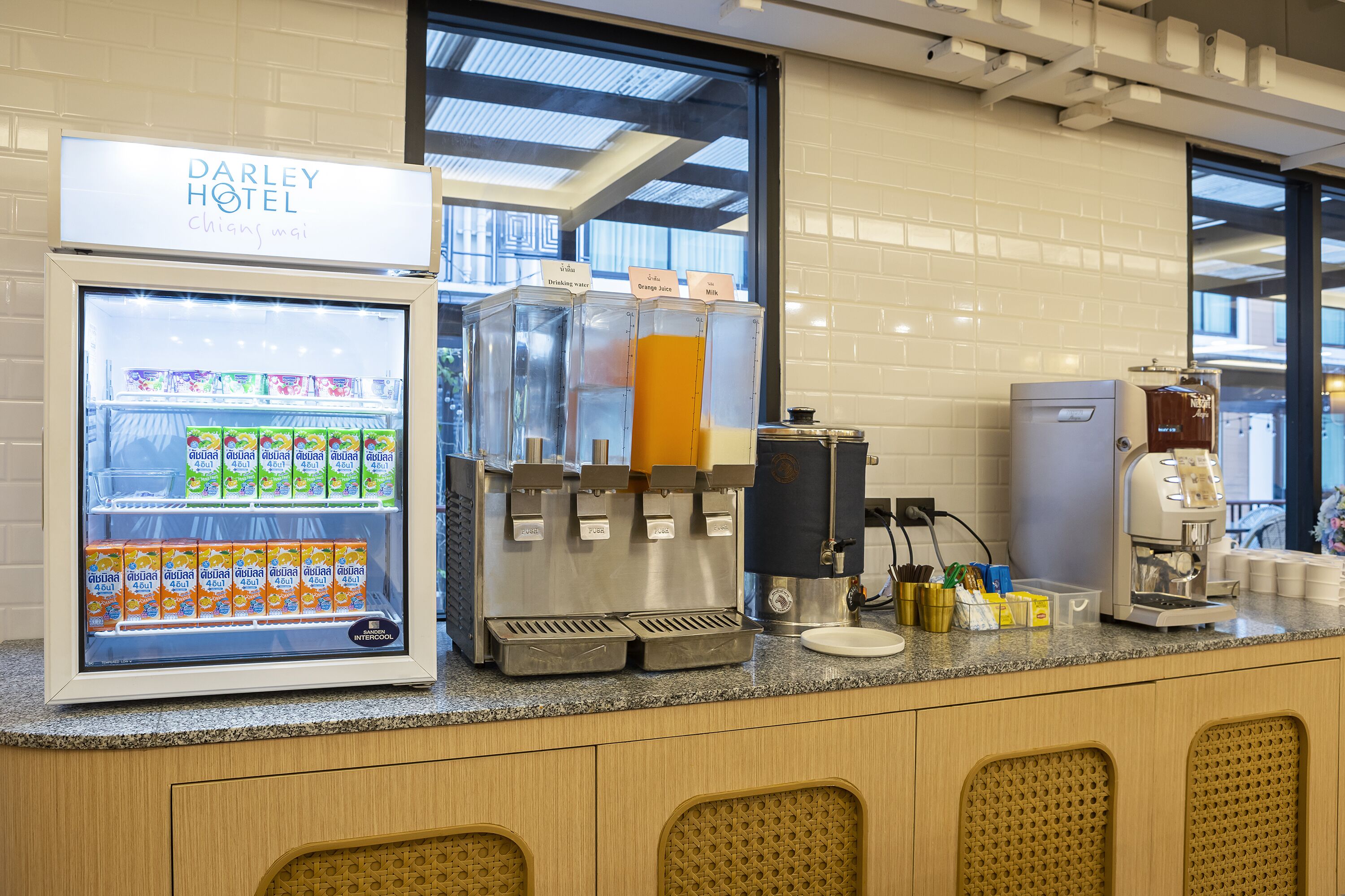 A self-service beverage station with a refrigerator stocked with drinks and a coffee machine.
