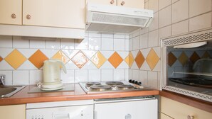 Een keuken met een fornuis, een koffiezetapparaat en een vaatwasser.