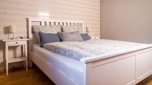 A bedroom with a bed, bedside tables, and a nightstand. - Alpenchalet Sachrang für 2 Personen (Sachrang)