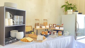 Een ontbijtbuffet met diverse soorten eten en bestek.