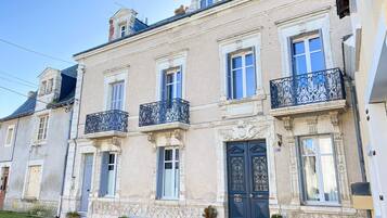 Classic architecture with symmetrical windows, ornate balcony railings, and a central entrance.