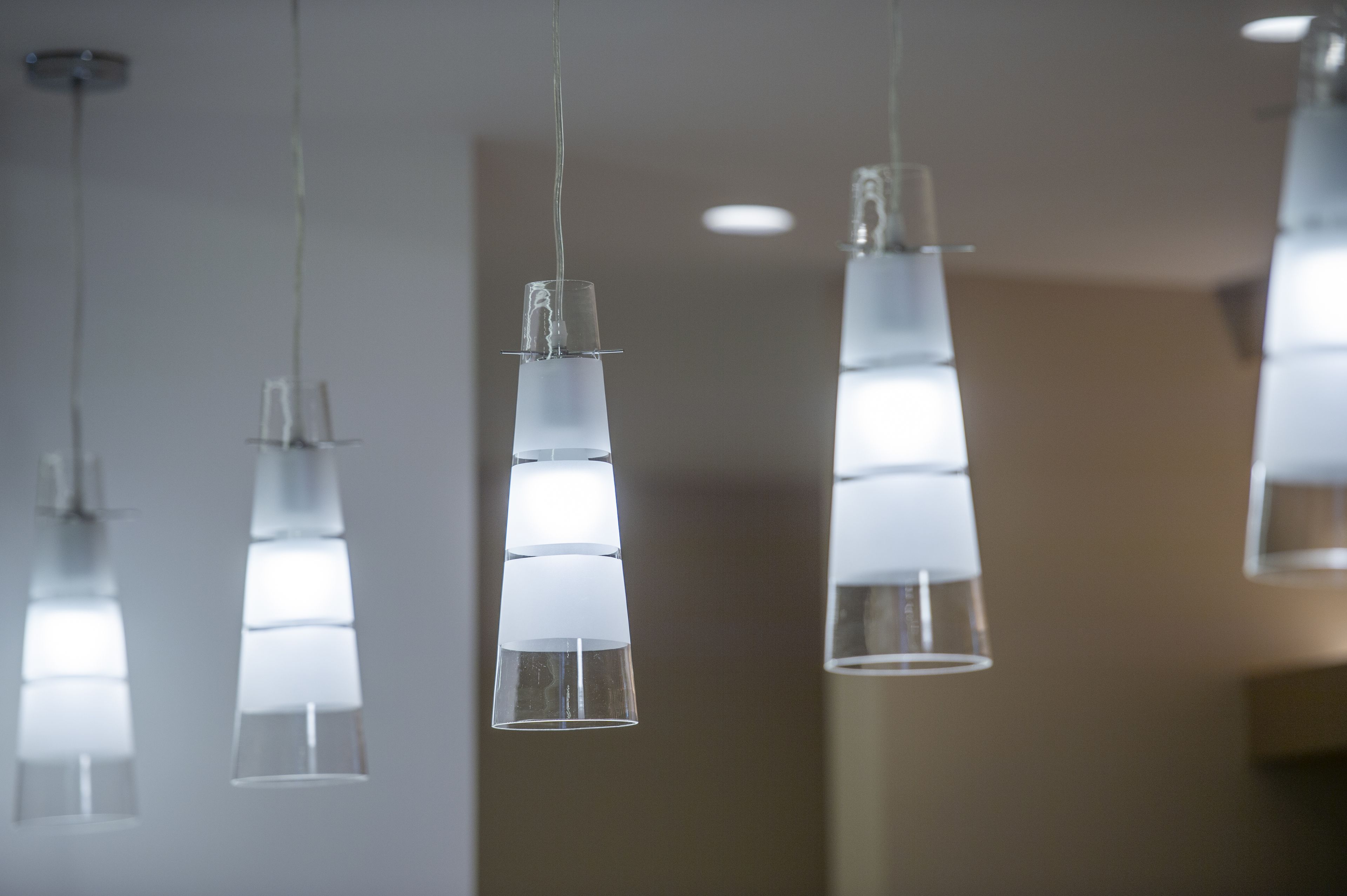 A series of hanging pendant lights with a clear, cylindrical design.