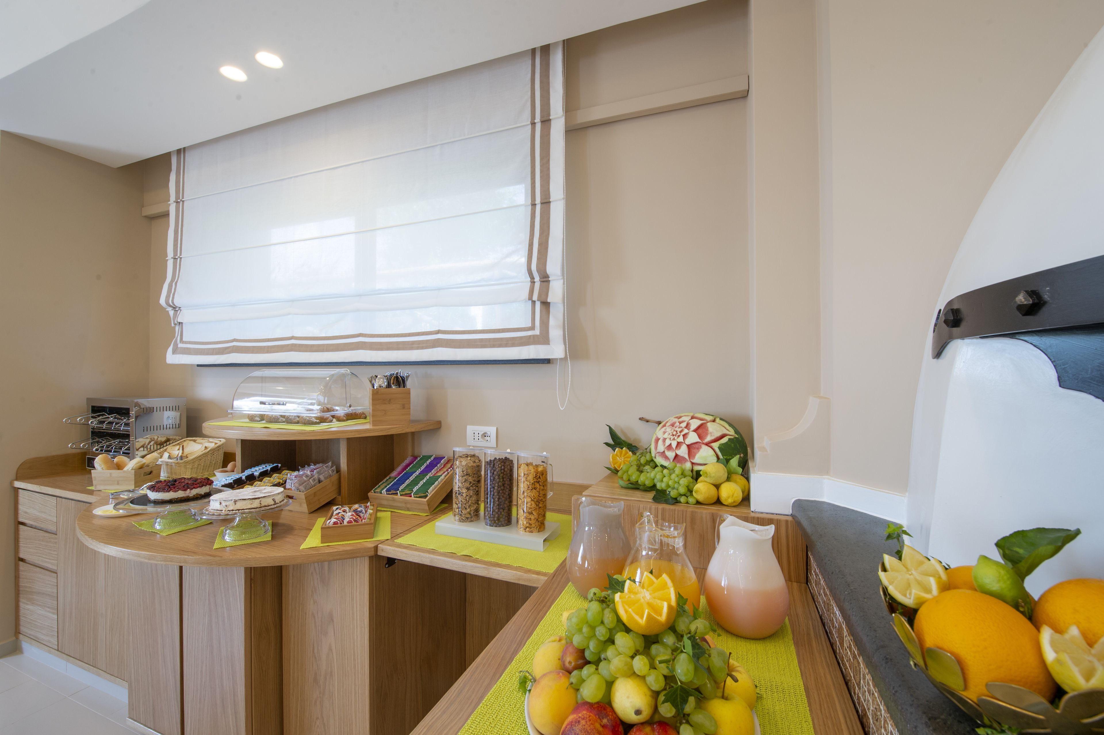 A breakfast buffet with various food items and a fruit display.