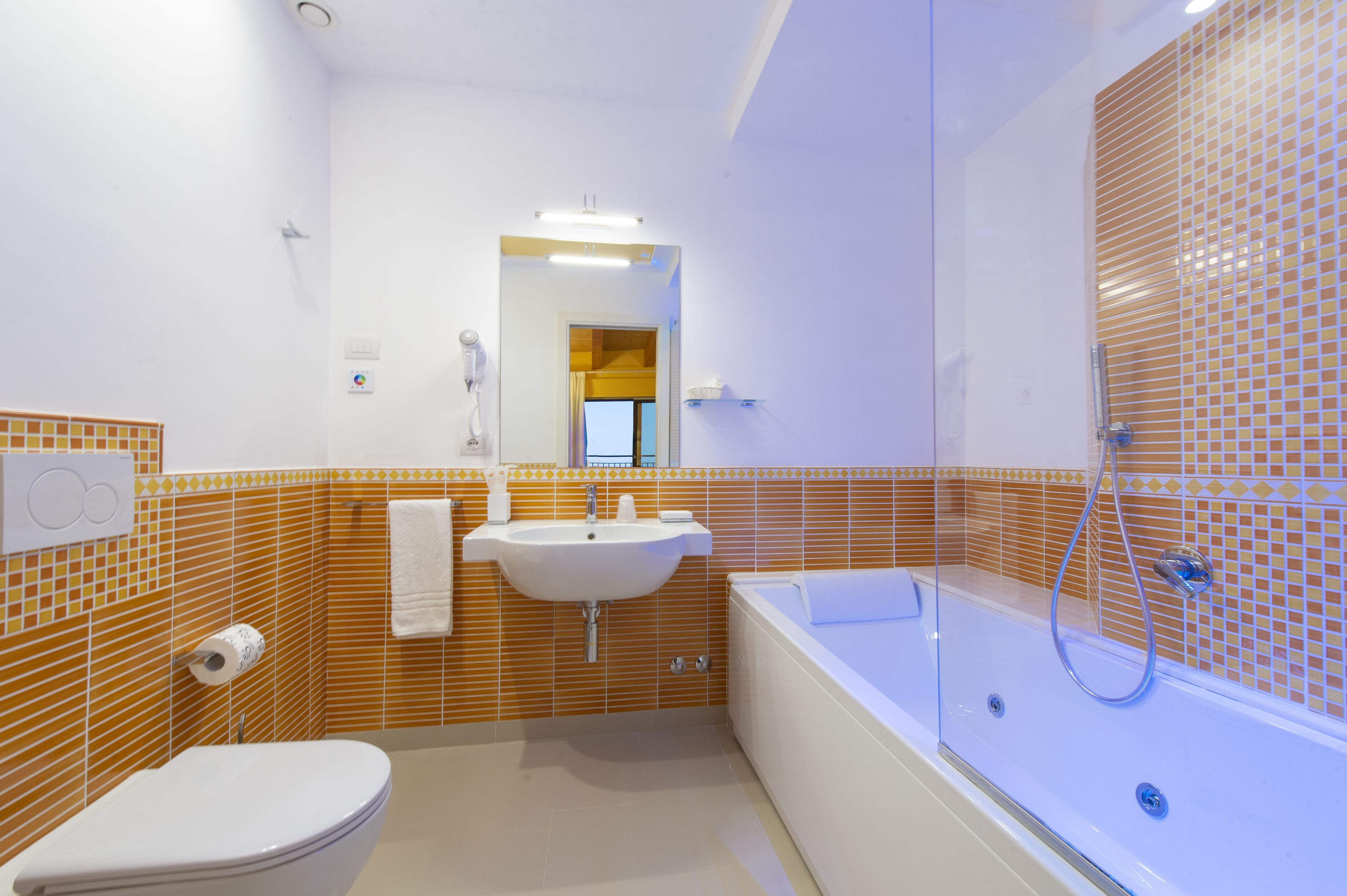 A modern bathroom with a toilet, sink, and bathtub.