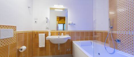 A modern bathroom with a toilet, sink, and bathtub.