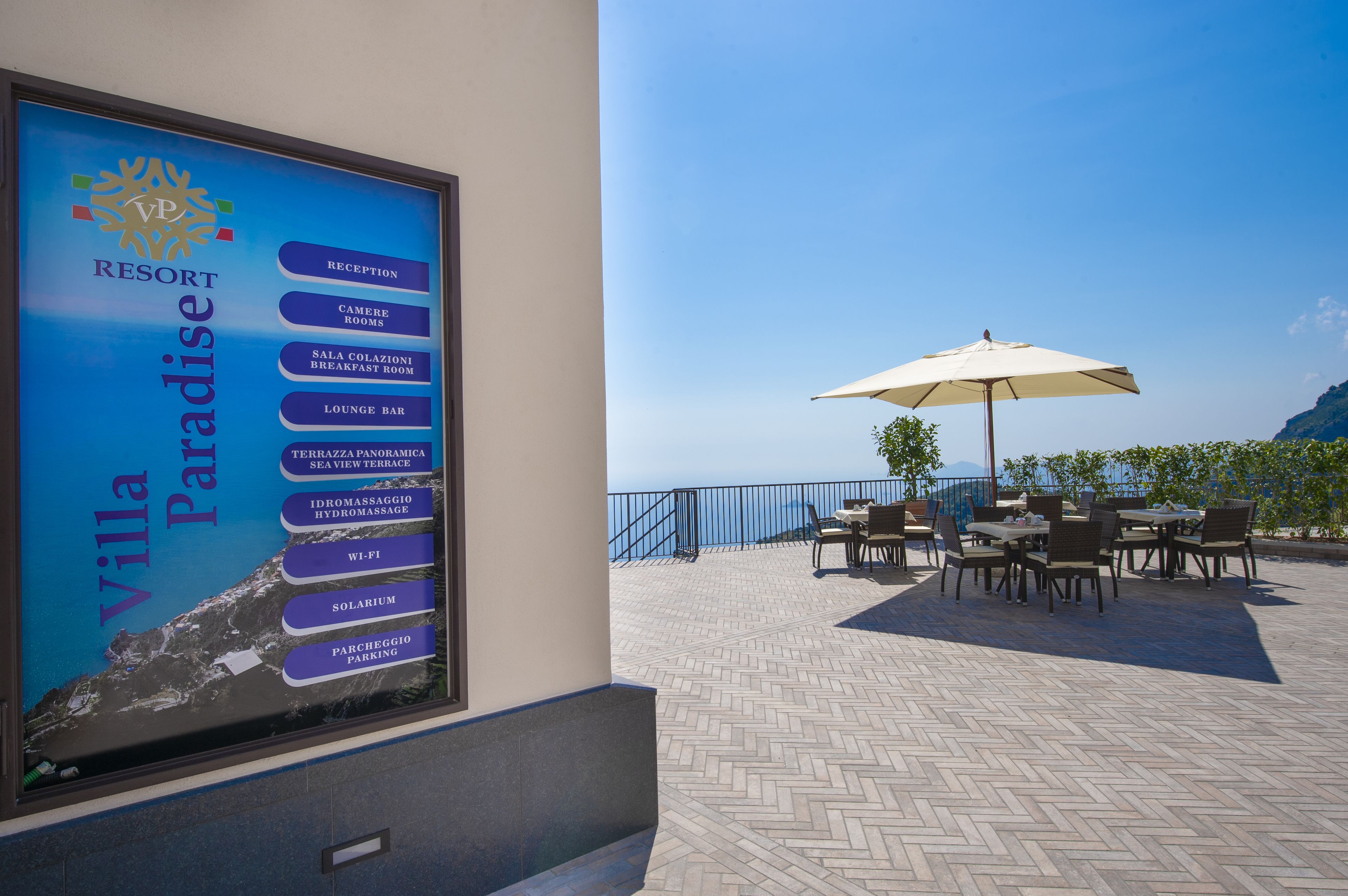 Letrero de un resort que enumera servicios como recepción, habitaciones, desayuno y Wi-Fi.