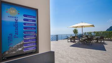 Letrero de un resort que enumera servicios como recepción, habitaciones, desayuno y Wi-Fi.