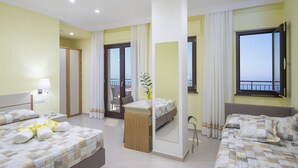 A hotel room with two beds, a desk, a chair, a balcony with a view, and a large mirror. - Villa Paradise Resort (Agerola)