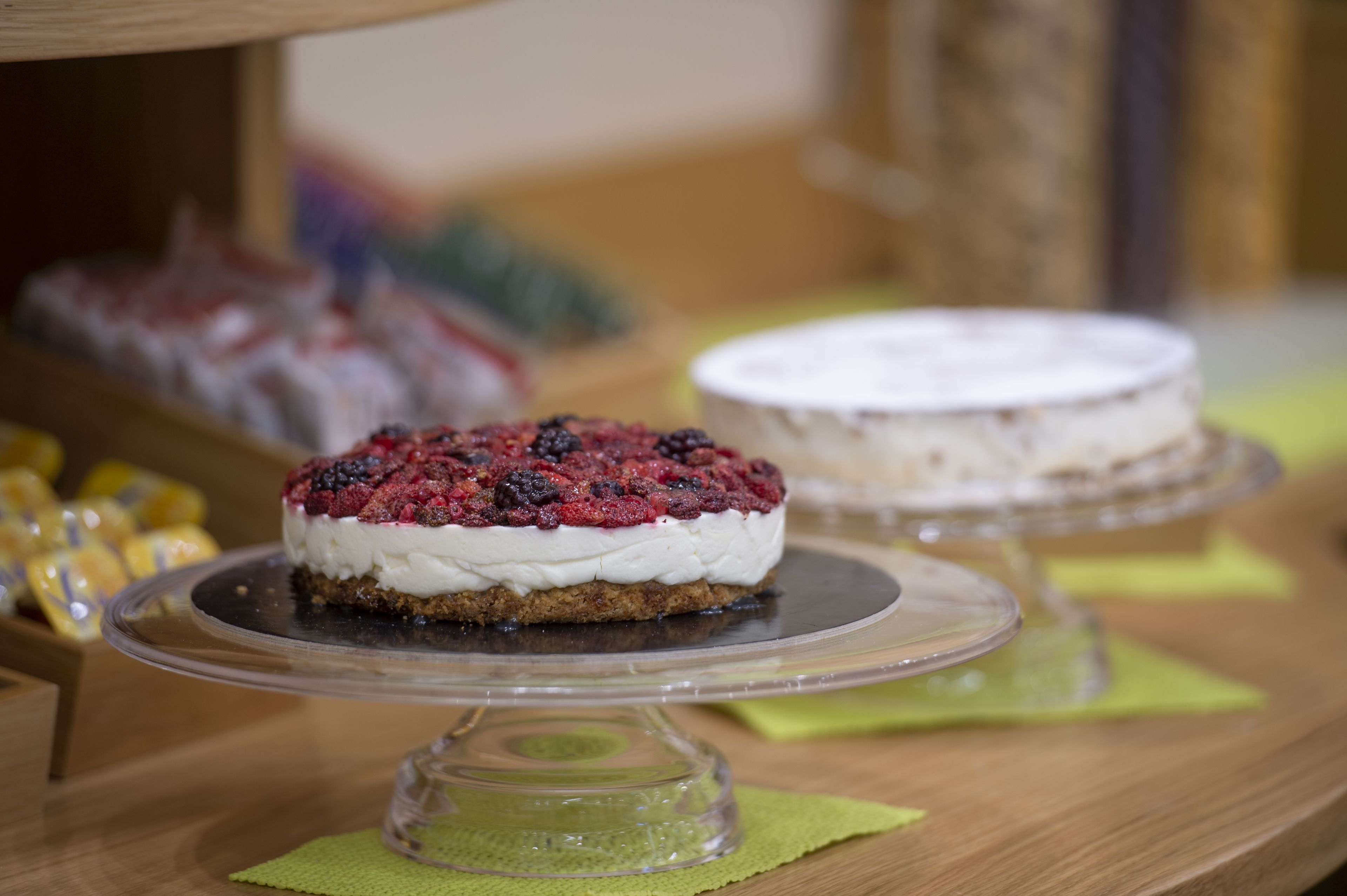 A dessert display with various cakes and pastries on glass stands.