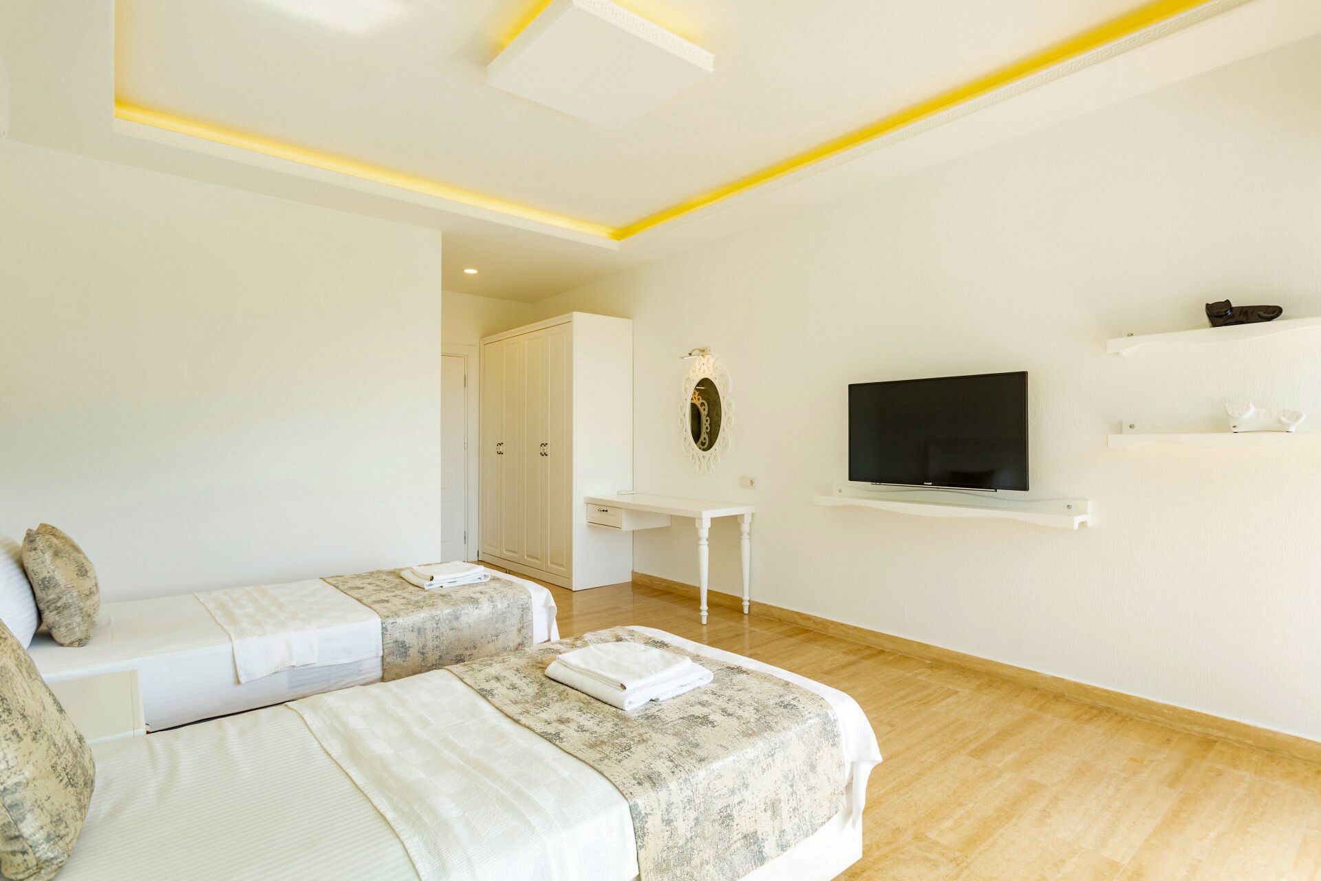 A hotel room with two beds, a TV, a desk, and a wardrobe.