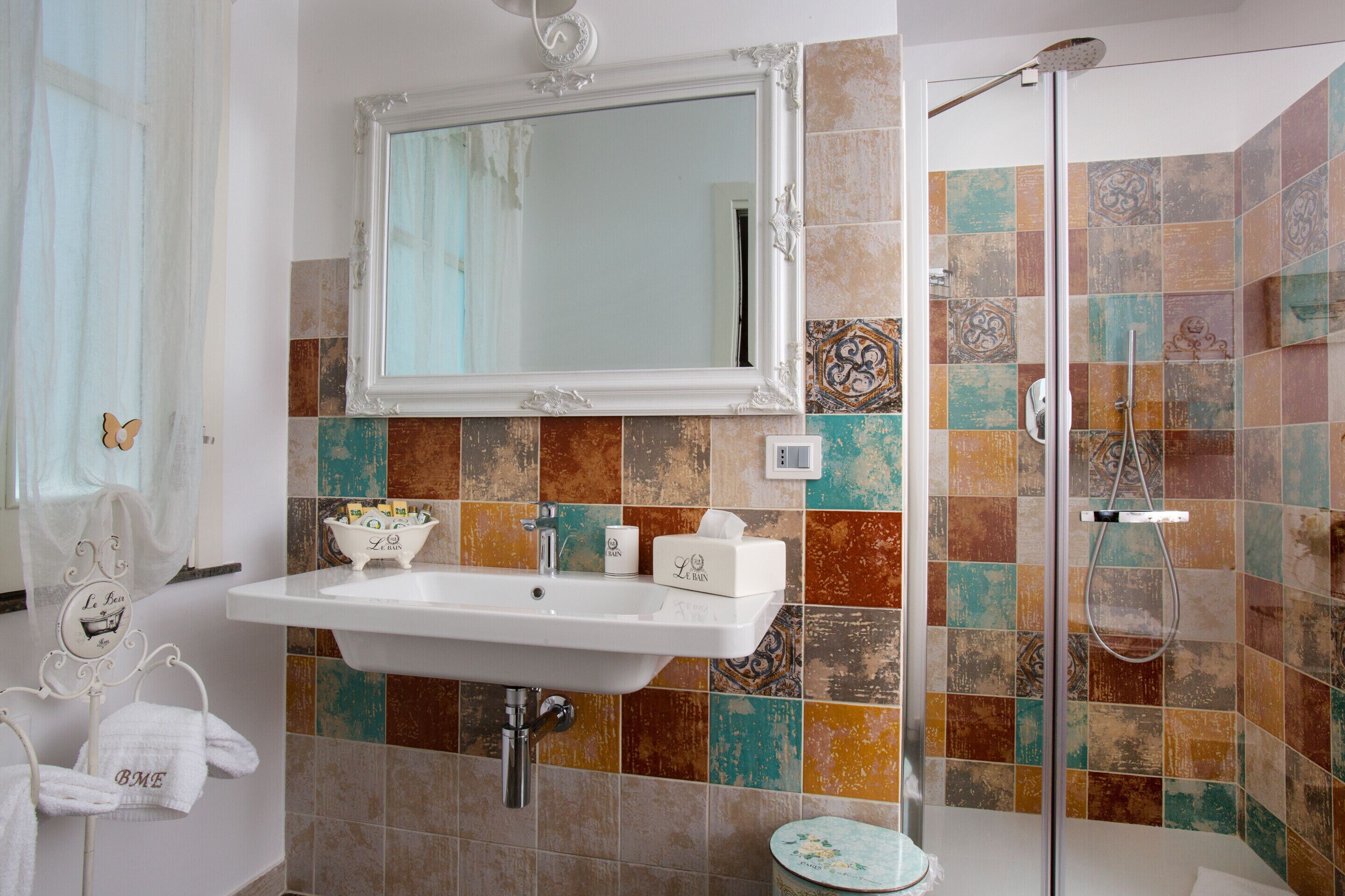 A bathroom with a white sink, a mirror, and a shower.