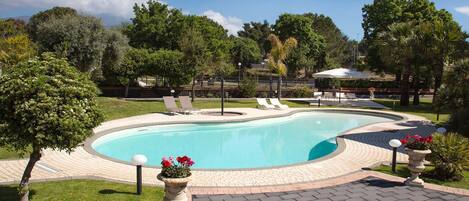 Una piscina al aire libre de temporada, sombrillas
