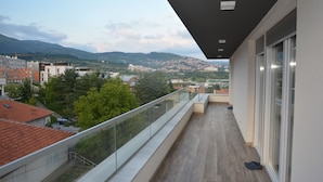 A balcony with a view of a cityscape, including buildings and hills in the distance. - Hotel Family (Sarajevo)